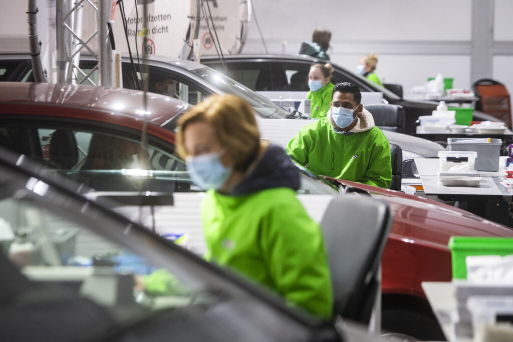 Medewerkers met groene GGD-jassen in de teststraat