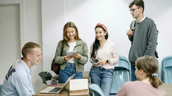 5 jongeren staan te praten op school.